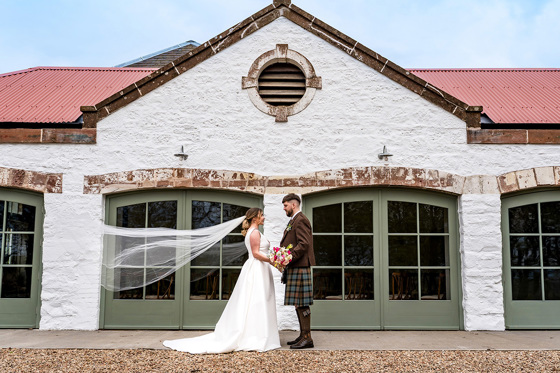 Bride and groom in front of Kinclune Steading